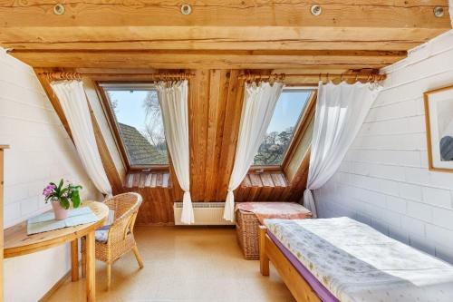 a room with a bed and a table and two windows at Haus Habbinga in Ovelgönne