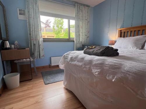 a bedroom with a large bed and a window at Black Isle View in Dingwall