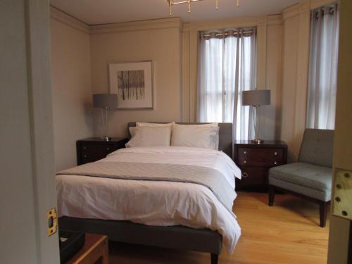 1 dormitorio con 1 cama grande y 1 silla en Washington Park Inn en Albany