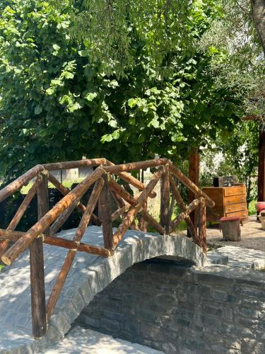 a wooden bridge over a river in a park at GuestHouse "Shtëpia ime" in Përmet