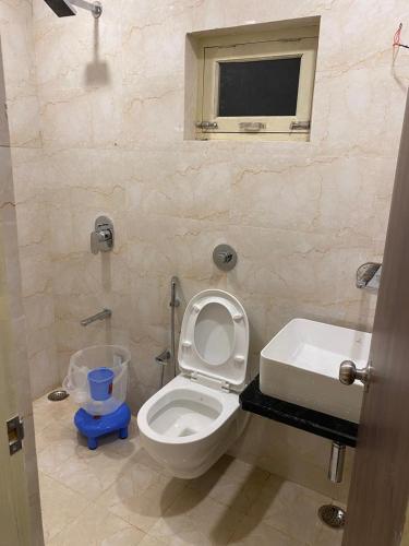a bathroom with a toilet and a sink and a window at Sky Mount Villa in Mount Ābu