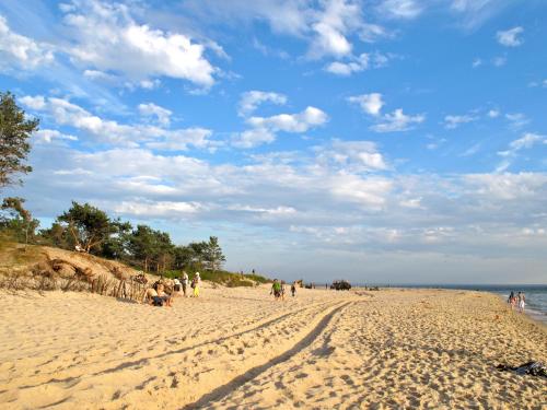 un grupo de personas caminando por una playa de arena en Słoneczny Hel, en Hel
