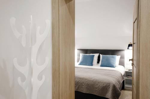 a bedroom with a bed with blue pillows at Apartamenty MISTRAL in Karpacz