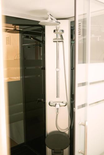 a shower in a bathroom with a chair at Zomerhuisje Chalet in Voorthuizen