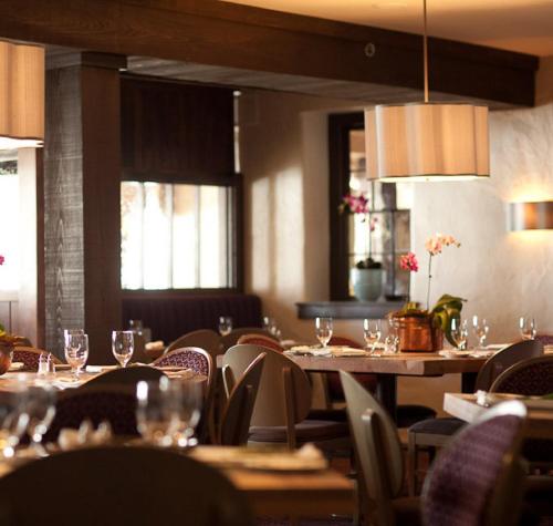 a restaurant with tables and chairs with wine glasses at Normandy Farm Hotel & Conference Center in Blue Bell