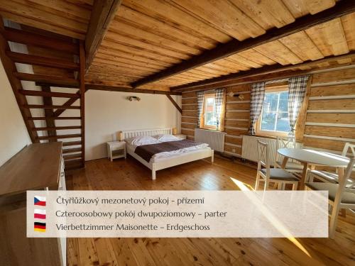 a bedroom with a bed and a table and chairs at Penzion Muštelka in Rokytnice nad Jizerou