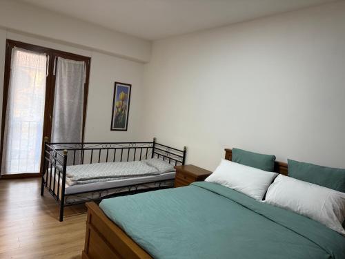 a bedroom with two beds and a couch and a window at Casa di Nina in Grazzano Badoglio