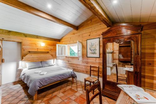 a bedroom with a bed in a room with wooden walls at La palombière in Saint-Symphorien