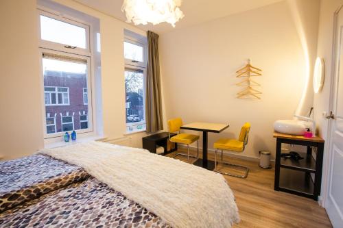 een slaapkamer met een bed, een tafel en stoelen bij Puur Geluk in Groningen