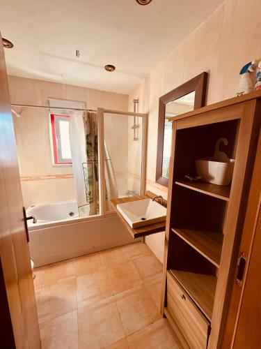 a bathroom with a tub and a sink and a mirror at Gama Barros 22 in Charneca