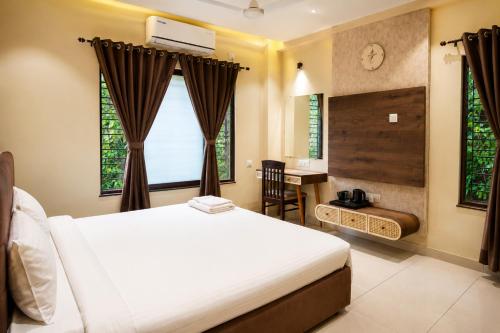 a bedroom with a bed and a desk and a window at IND57 in Siliguri
