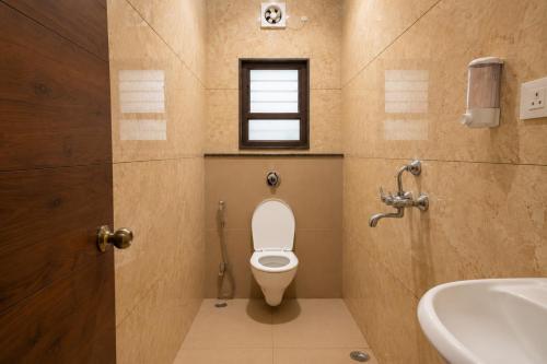 a bathroom with a toilet and a sink and a window at IND57 in Siliguri