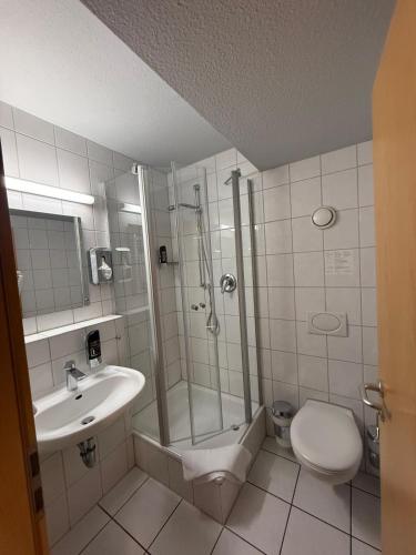 a bathroom with a shower and a sink and a toilet at Central Hotel Winnenden in Winnenden