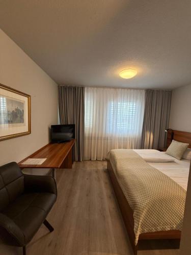 a hotel room with a bed and a desk with a computer at Central Hotel Winnenden in Winnenden