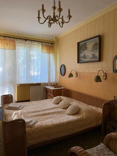 a bedroom with a bed and a chandelier at Kanu Club - ośrodek wypoczynkowy in Nowy Zyzdrój