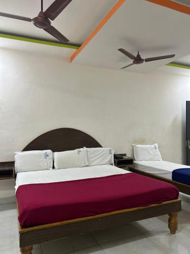 a bedroom with two beds and a ceiling fan at Srilakshmi Residency in Tirupati