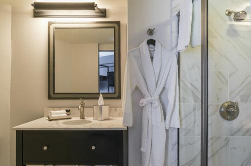 a bathroom with a shower and a white robe at The Boxer in Boston