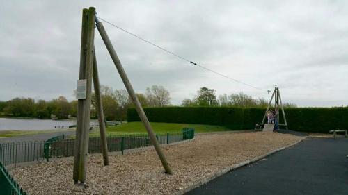 a swing set in a park with people on it at Maindee Guest House in Barrow in Furness