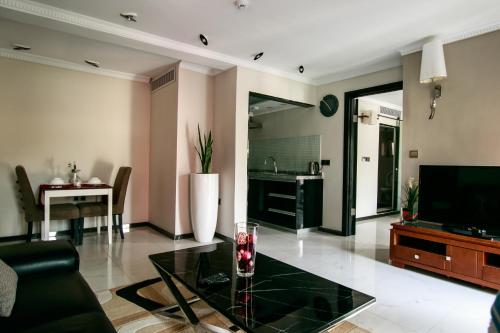 a living room with a glass table and a television at Red Mango Hotel and Apartments in Takoradi