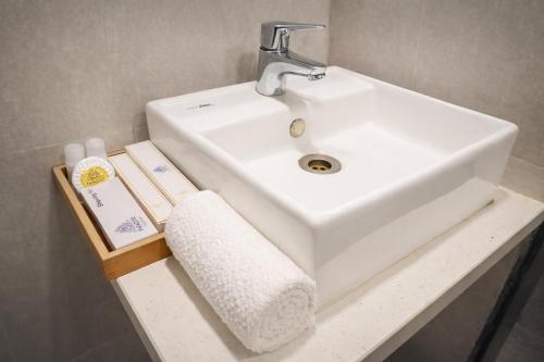 a bathroom sink with a towel and a book on a shelf at Hotel Paradise in Chākan