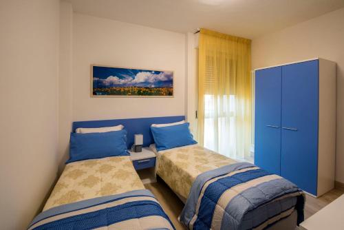 una camera con due letti e un armadio blu di Affittacamere Le Quattro Stagioni a Pisa