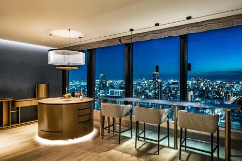 a bar in a room with a view of a city at The Gate Hotel Osaka by Hulic in Osaka