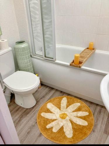 a bathroom with a toilet and a rug on the floor at Cosy Seaside Snug in Helensburgh
