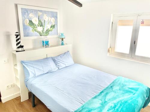 a bed in a bedroom with a vase of flowers at El Rincón de Salsipuedes in Cudillero