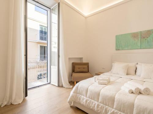 a white bedroom with a large bed and a window at Casa Del Barone Suites in Monopoli