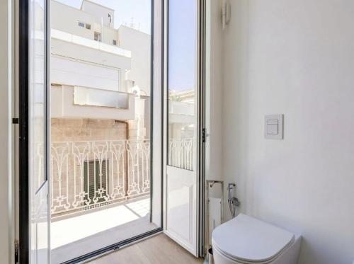 a bathroom with a toilet and a large window at Casa Del Barone Suites in Monopoli
