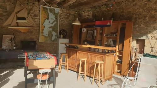 a kitchen with a table and some stools and a counter at Chez Patoue Gîte et Chambre d'hôtes in Sanvensa