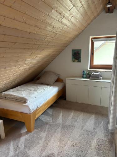 a bed in a room with a wooden ceiling at Cozy Apartment in Wülfrath