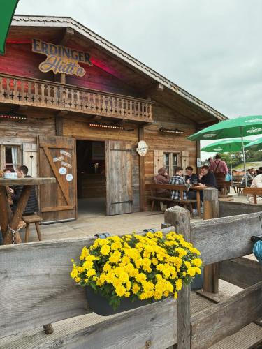a restaurant with yellow flowers in front of a building at Wies'n Camp in Munich