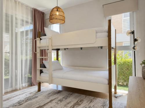 two bunk beds in a room with a window at Nothern Cyprus Four Seasons Life Collection Apartments & Lofts Seafront in Ayios Dhometios