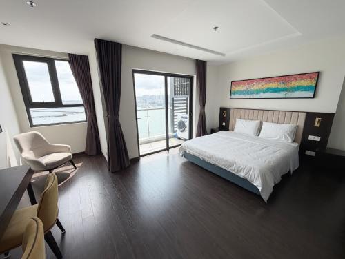 a bedroom with a bed and a desk with a chair at The Sapphire Hòn Gai Apartment - Trung tâm Hạ Long in Ha Long