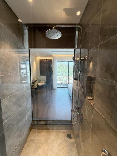 a bathroom with a shower with a glass door at The Sapphire Hòn Gai Apartment - Trung tâm Hạ Long in Ha Long