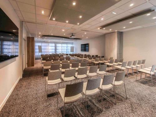 a conference room with a long table and chairs at Ibis Styles Clermont-Ferrand République in Clermont-Ferrand