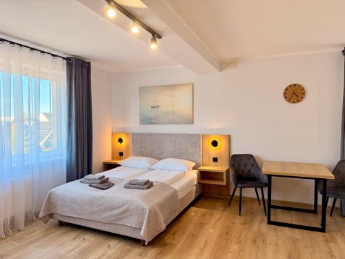a bedroom with a bed and a table and a desk at Apartamenty Flauta - Cisza i Spokój, Parking, WiFi, Balkon, Aneks kuchenny in Jastrzębia Góra