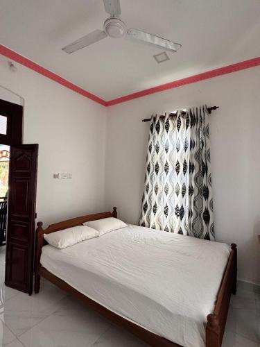 a bedroom with a bed and a ceiling fan at Radiance Inn in Jaffna