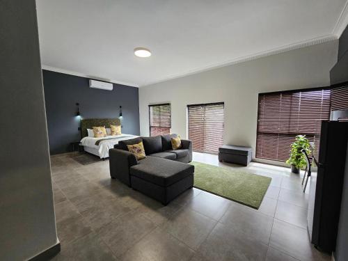a living room with a couch and a bed at Namloom Guesthouse in Pretoria