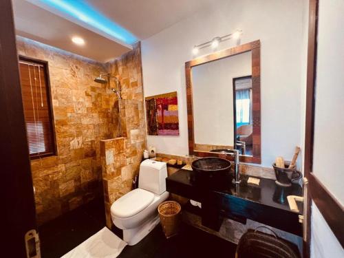 a bathroom with a toilet and a sink and a mirror at ViewPoint Ecolodge in Nyaungshwe Township