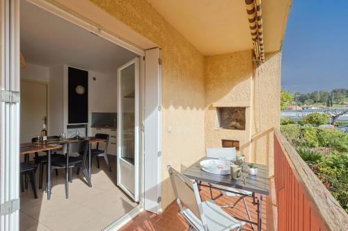 an open balcony with a table and chairs on a patio at A deux pas de la plage de sable in Le Pradet