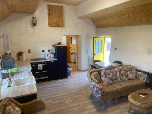 a living room with a couch and a kitchen at The Thatched Cottage in Cork