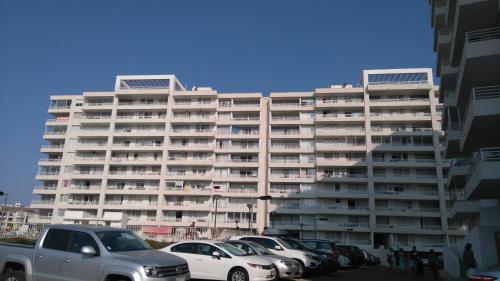 un gran edificio con coches estacionados en un estacionamiento en Yasna Gorigoitia, en La Serena
