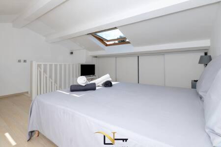 a bedroom with a white bed and a skylight at Cozy duplexterrace barbecue pool beach on foot in Le Pradet