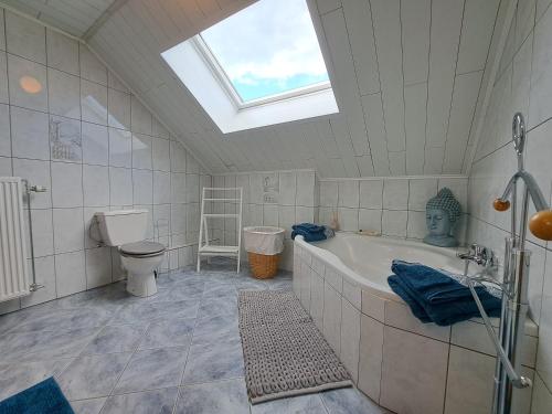 a bathroom with a tub and a toilet and a skylight at Chez Baf - Wibrin - Houffalize in Wibrin