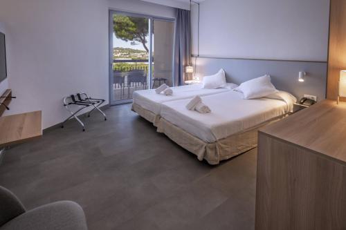 a hotel room with a bed and a balcony at GHT S'Agaró Mar Hotel in Sant Feliu de Guíxols