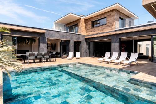 a villa with a swimming pool and a house at Villa Signature Luxury & Exclusive seaside getaway in Le Grau-dʼAgde