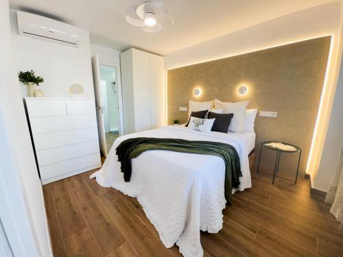 a bedroom with a large bed with white sheets at Bright Flat 1 min from Beach with parking in Fuengirola
