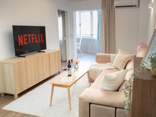 a living room with a television on a cabinet at Bright Flat 1 min from Beach with parking in Fuengirola
